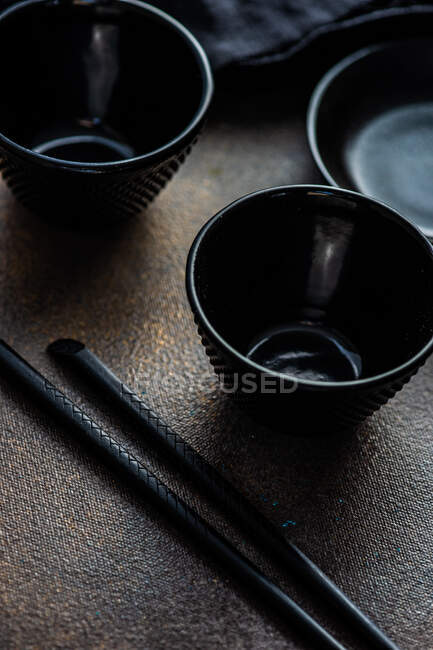 Place setting for dinner with asian food with bowl and chopsticks on rustic background — Stock Photo