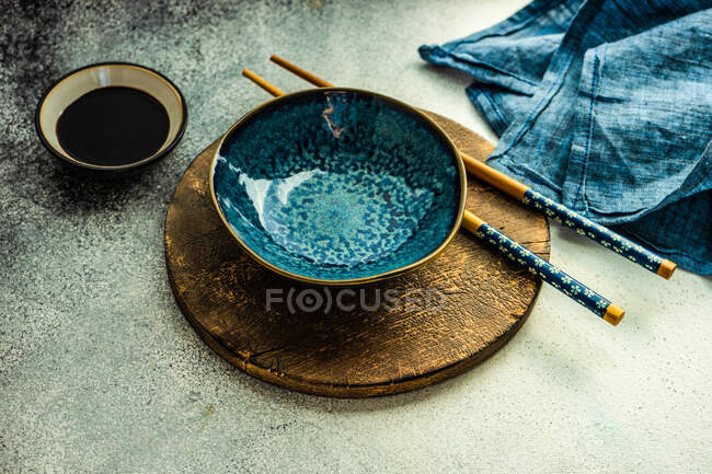 Placer le cadre pour le dîner avec de la nourriture asiatique avec bol et baguettes sur fond rustique — Photo de stock