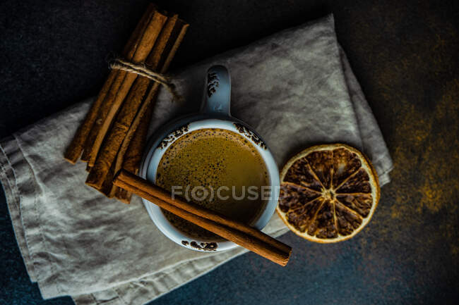 Горщик гарячого шоколаду з паличками кориці та апельсином на сільському фоні з копією простору — стокове фото