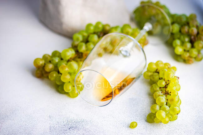 Стакан грузинского вина Rkatsiteli в стакане и свежий сырой виноград на деревенском столе — стоковое фото