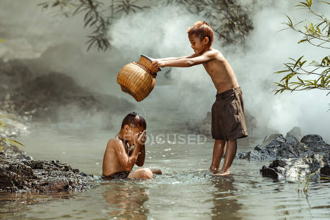 Dos chicos lavándose en un río, Tailandia - foto de stock