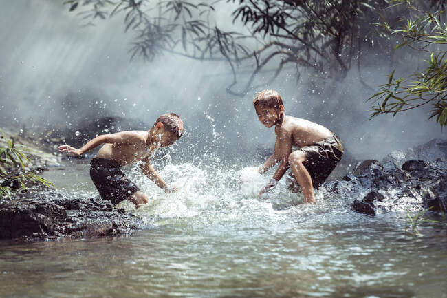 Zwei Jungen waschen sich in einem Fluss, Thailand — Stockfoto