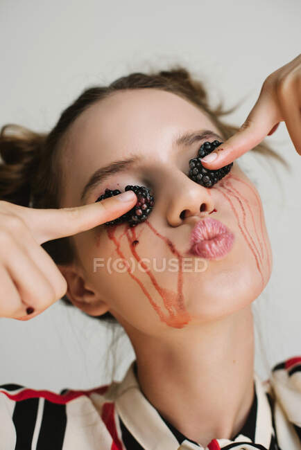 Ritratto di una donna che schiaccia more sulle palpebre, cura concettuale della pelle — Foto stock