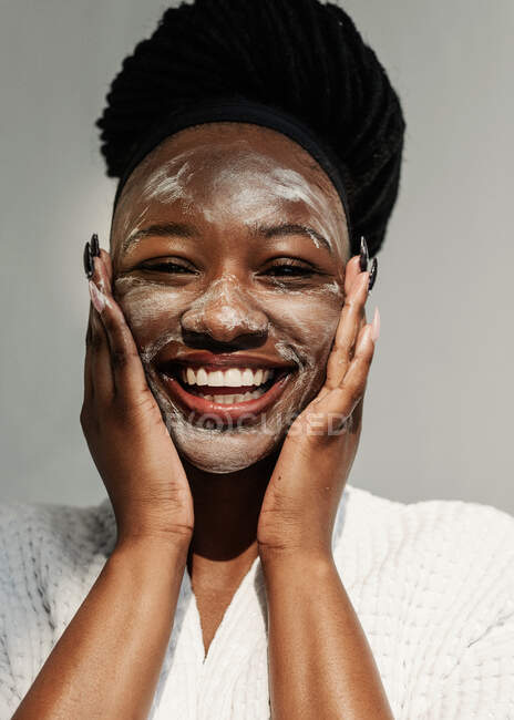 Портрет улыбающейся женщины в маске для лица — стоковое фото