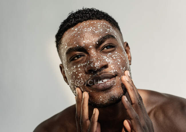 Portrait of a smiling man with glitter on his face — Stock Photo