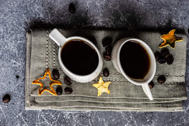 Canecas brancas de cerâmica com bebida de café quente em fundo têxtil cinza — Fotografia de Stock