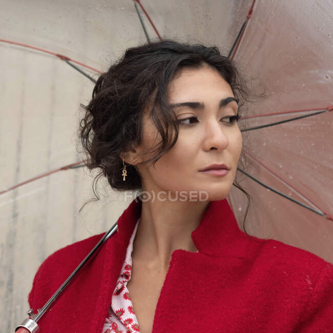 Portrait of a woman standing under an umbrella — Stock Photo