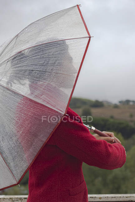 Retrato de una mujer de pie bajo un paraguas - foto de stock
