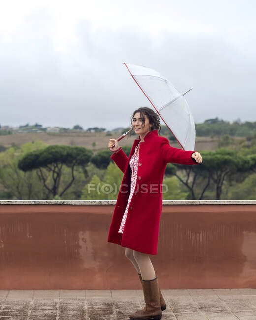 Mujer bailando bajo la lluvia con un paraguas, Roma, Lazio, Italia - foto de stock