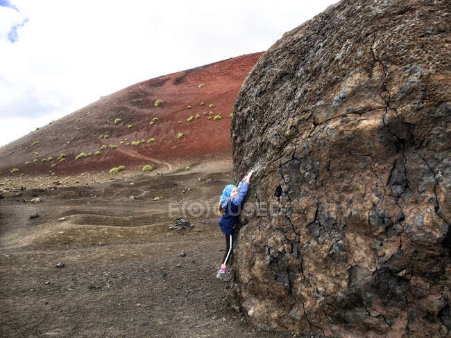 Ragazza sorridente appesa ad una roccia, Lanzarote, Isole Canarie, Spagna — Foto stock