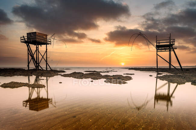 Long exposure shot of Fishing huts on beach at low tide at sunset, Saint-Michel-Chef-Chef, Loire-Atlantique, France — Stock Photo