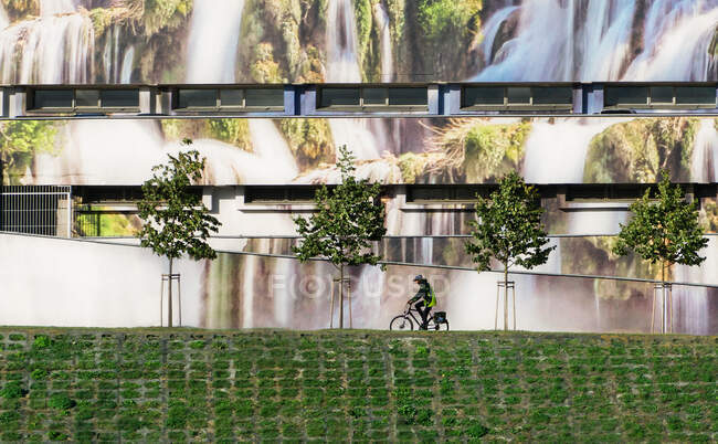Ciclista pasando por un edificio, Vilnius, Lituania - foto de stock