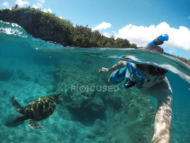 Homme plongeant en apnée dans l'océan avec une tortue de mer, Maui, Hawaï, États-Unis — Photo de stock