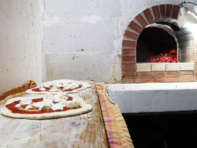 Two pizzas ready to go into the pizza oven, Italy — Stock Photo