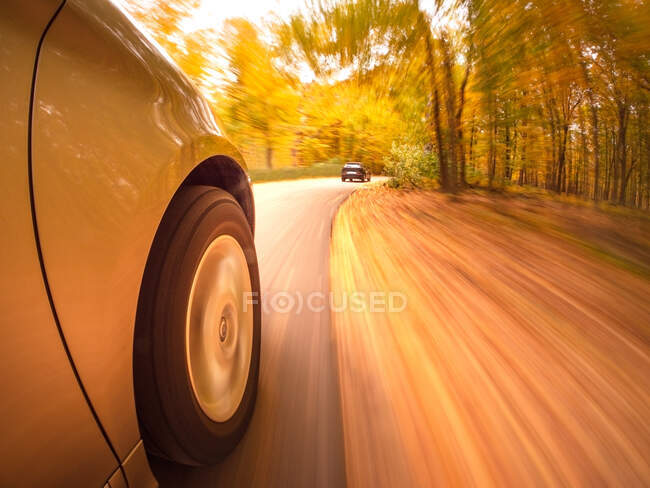 Car speeding along a road in autumn, USA — Stock Photo