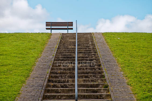 Скамейка на дамбе в верхней части лестницы, Восточная Фризия, Нижняя Саксония, Германия — стоковое фото