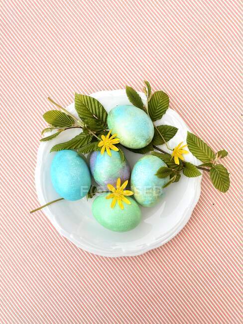 Bowl of blue Easter eggs with flowers — Stock Photo