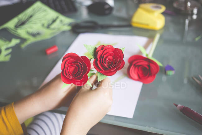 Boy making red roses for St Jordi Day, Spain — Stock Photo