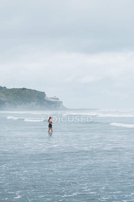 Frau in der Brandung des Meeres, Mangawhai Heads, Northland, North Island, Neuseeland — Stockfoto