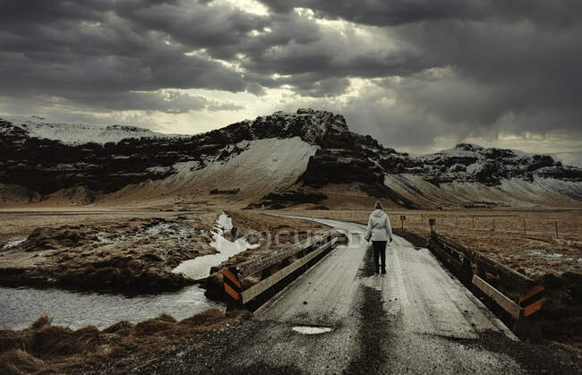 Женщина идет по дороге, Исландия — стоковое фото