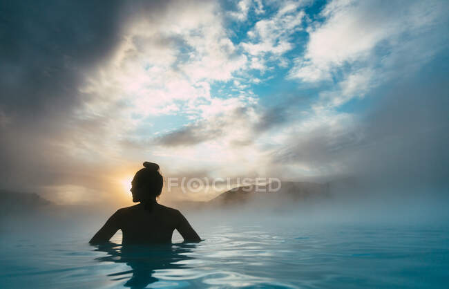 Silhueta de uma mulher em pé na Lagoa Azul, Islândia — Fotografia de Stock