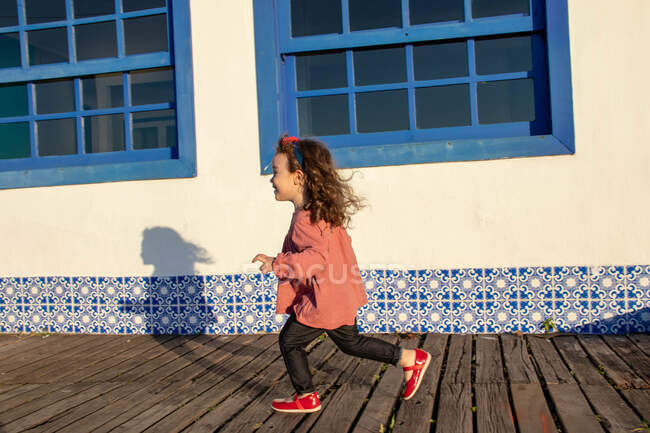 Девушка бежит по деревянной набережной, Armacao dos Buzios, Рио-де-Жанейро, Бразилия — стоковое фото