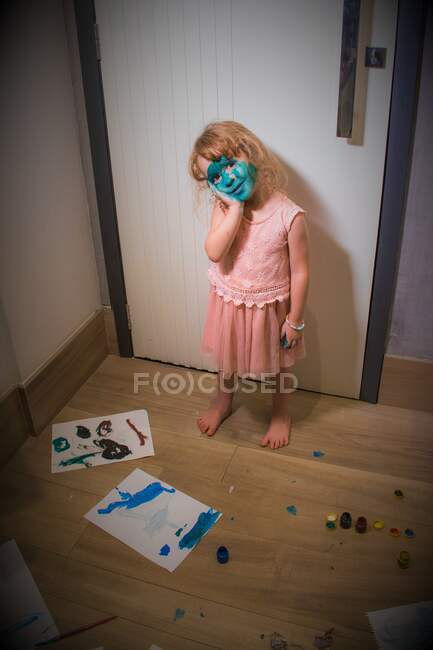 Portrait of a mischievous girl with paint on her face — Stock Photo