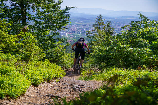 Woman mountain biking through the forest, Klagenfurt, Carinthia, Austria — Stock Photo