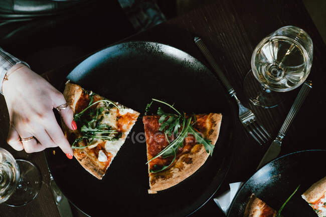 Vista aerea di una donna che cerca una fetta di pizza — Foto stock