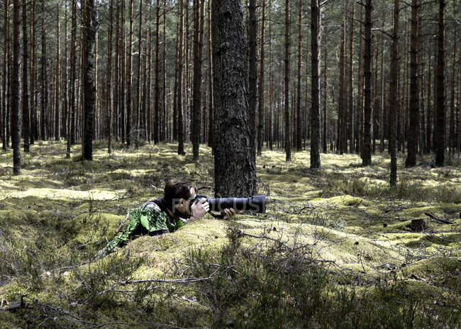 Fotografo nella foresta che scatta foto con un obiettivo lungo, Lituania — Foto stock