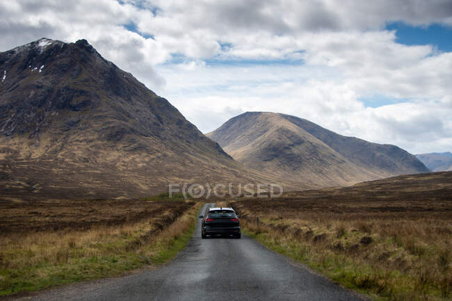 Car driving towards mountains, Glencoe, Scottish Highlands, Scotland, UK — Stock Photo