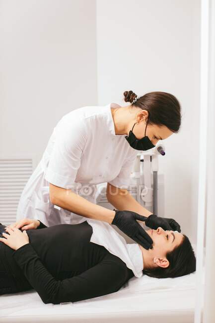 Kosmetikerin bereitet eine Frau in einer Klinik auf eine Schönheitsbehandlung mit Carbon Peel vor — Stockfoto
