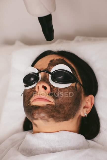Mujer que tiene un tratamiento de belleza cáscara de carbono - foto de stock