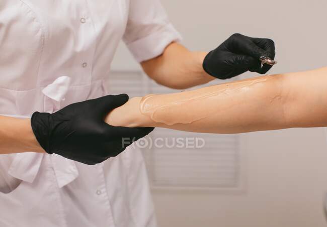 Esthéticienne appliquant un gel pour un traitement d'épilation au laser dans un salon de beauté — Photo de stock