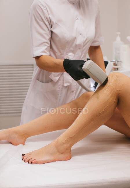 Femme ayant un traitement d'épilation au laser dans un salon de beauté — Photo de stock
