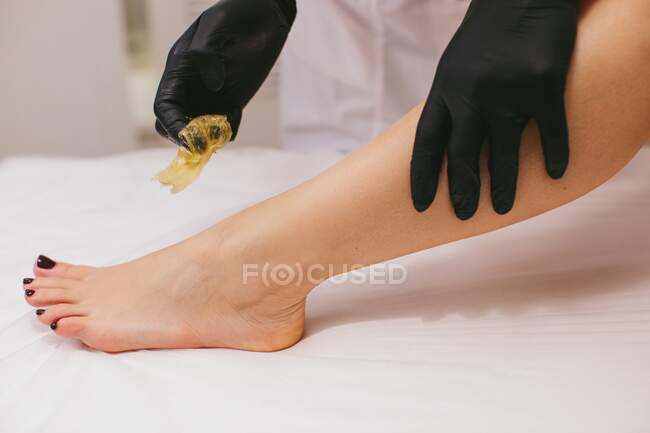 Женщине делают эпиляцию ноги в салоне красоты — стоковое фото