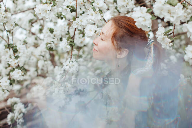 Посміхнена жінка пахне вишневим цвітом. — стокове фото