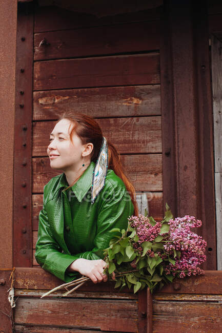 Femme debout à l'extérieur tenant des fleurs fraîchement cueillies — Photo de stock