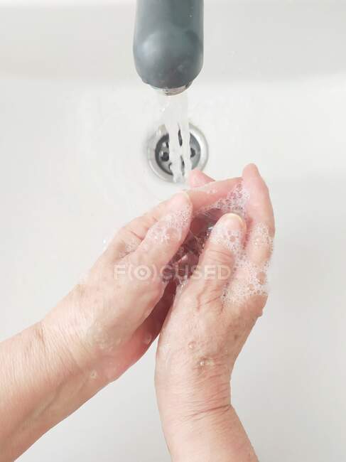 Vista aerea di una donna anziana che si lava le mani — Foto stock