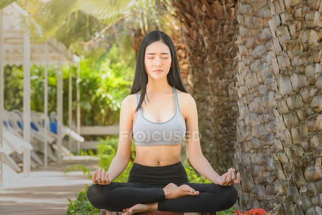 Schöne Frau sitzt in Lotus-Pose und meditiert, Thailand — Stockfoto