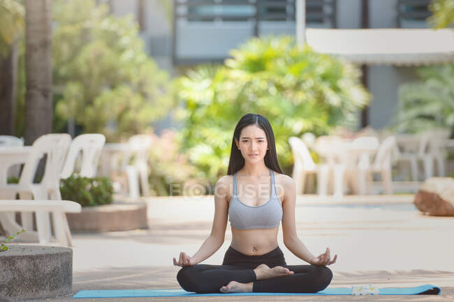 Hermosa mujer sentada en pose de loto meditando, Tailandia - foto de stock
