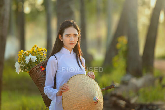 Hermosa mujer con ropa tradicional sosteniendo un sombrero non la, Tailandia - foto de stock