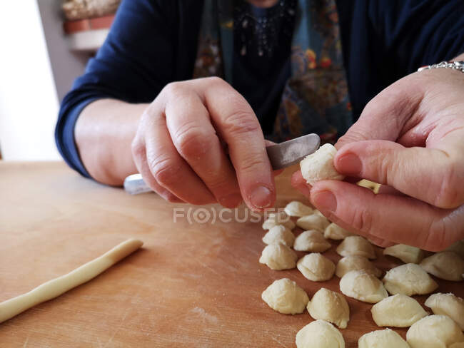 Женщина делает пасту из ореккьета апулии, Италия — стоковое фото