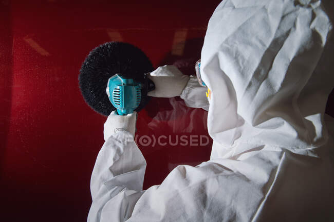 Mechanic wearing a clean suit polishing a car — Stock Photo
