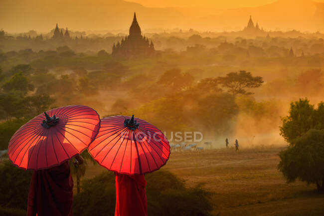 Vista posteriore di due monaci novizi con ombrelloni che guardano in vista, Bayan, Mandalay, Myanmar — Foto stock