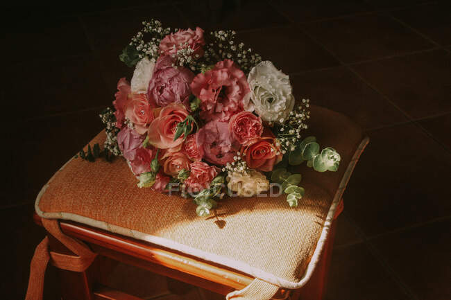 Свадебный букет на стуле под солнцем — стоковое фото