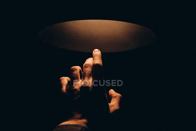 Man's hand reaching for the light — Stock Photo