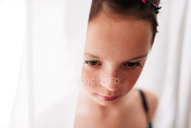 Портрет молодої дівчини в макіяжі, що стоїть на шторі — стокове фото