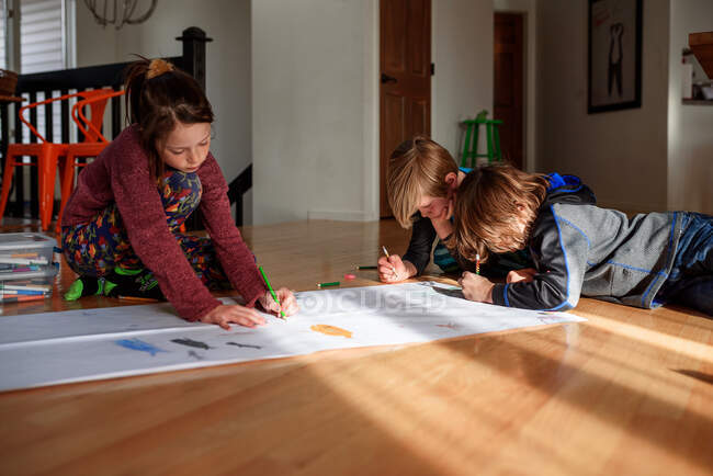 Three young children working on an art project at home — Stock Photo