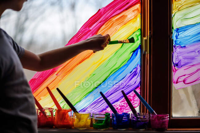 Хлопчик малює веселку на вікні, США. — Stock Photo